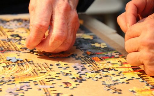 Hand placing a piece of jigsaw in a puzzle