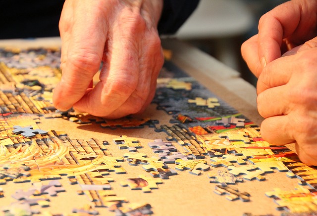 Hand placing a piece of jigsaw in a puzzle