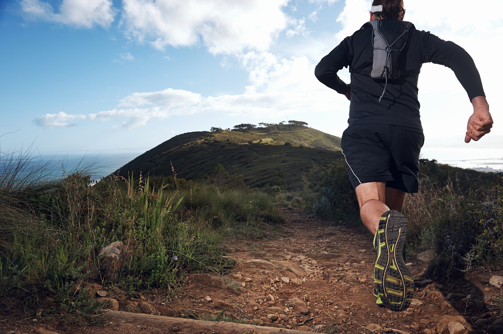 trail running man on mountain path exercising