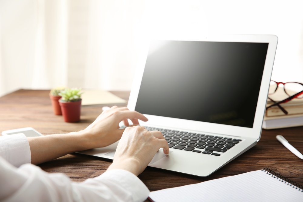 Woman working on computer at wooden desk