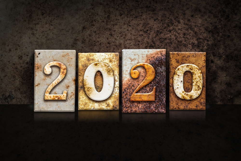 The word "2020" written in rusty metal letterpress type on a dark textured grunge background.